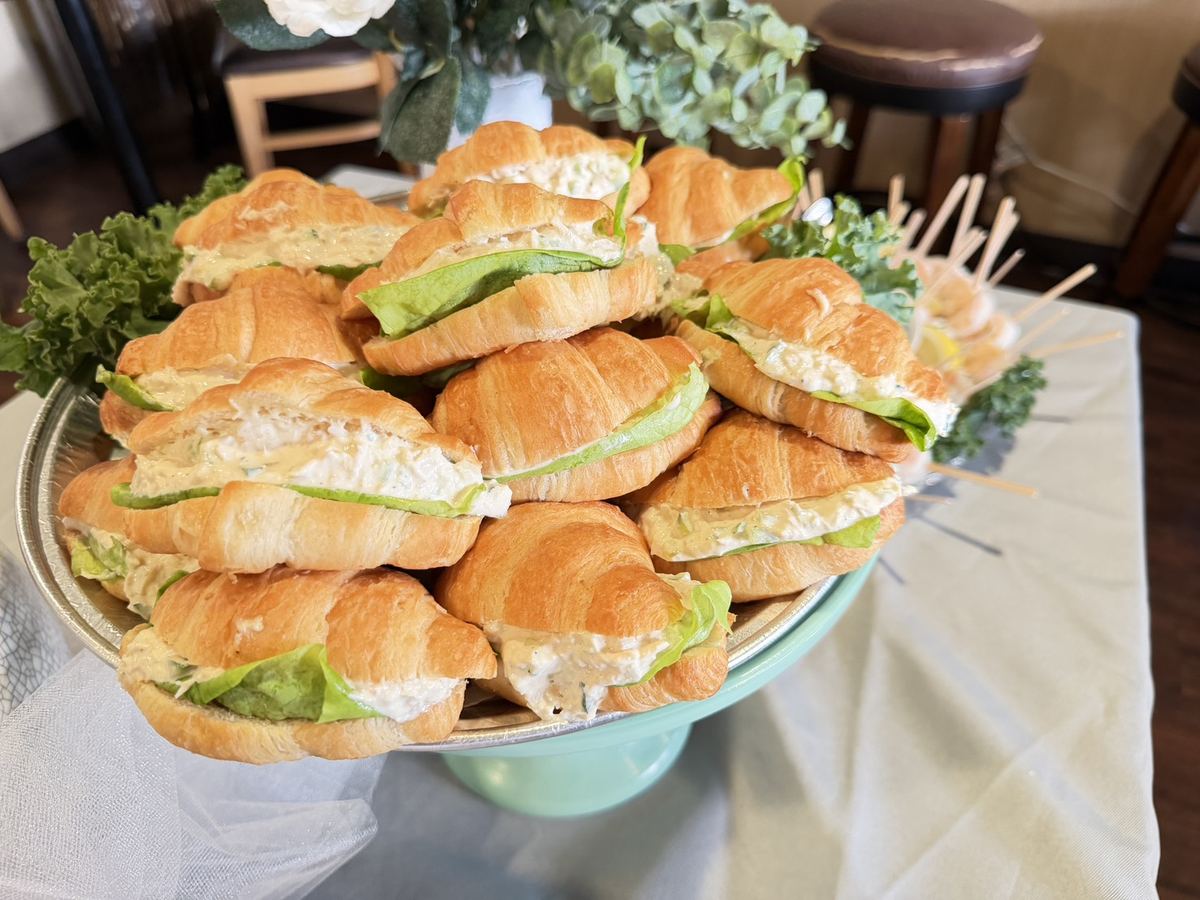 Platter of chicken salad croissant sandwiches with butter lettuce
