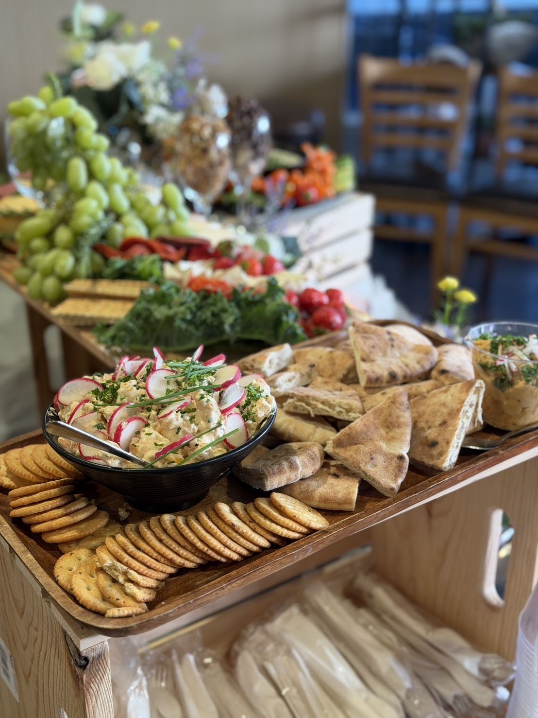 Catered buffet spread with dips, pita, crackers and fresh vegetables